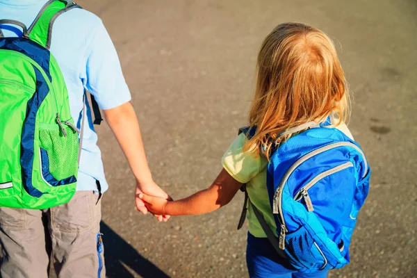 Мальчик и девочка держатся за руки и ходят в школу. — стоковое фото