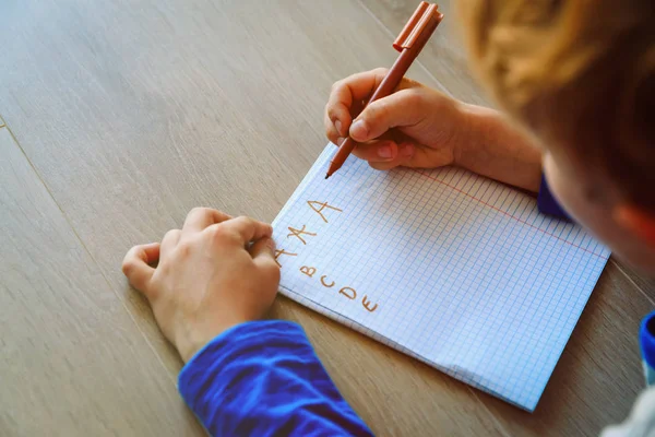 Niño aprendiendo a escribir cartas haciendo deberes — Foto de Stock