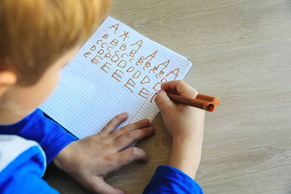 Kleine jongen leren schrijven brieven huiswerk — Stockfoto