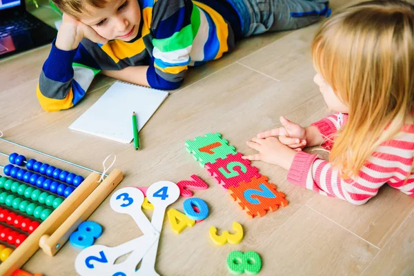 Liten pojke och flicka lära sig skriva och beräkna tal — Stockfoto