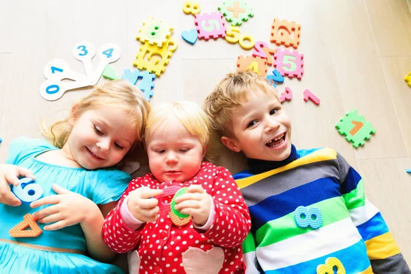 Šťastné malé dívky a chlapce učit čísla a tvary — Stock fotografie