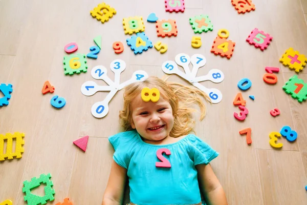 Lycklig liten flicka lära sig siffror och former, leka med pussel — Stockfoto