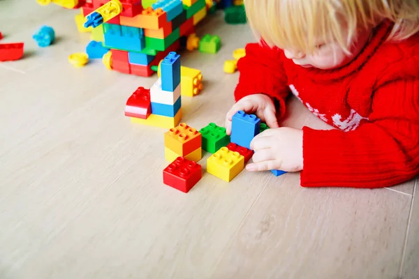 Pequeno bebê brincando com blocos de plástico coloridos — Fotografia de Stock