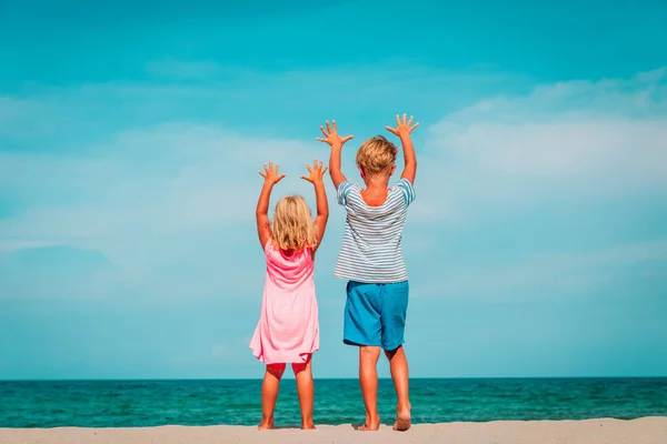 Boldog gyerekek-kisfiú és lány- érezd jól magad a strandon — Stock Fotó