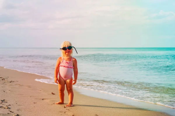 Симпатичная маленькая девочка с купальными гуглами на пляже — стоковое фото