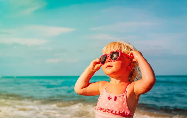 Plajda güneş gözlüklü şirin küçük kız — Stok fotoğraf