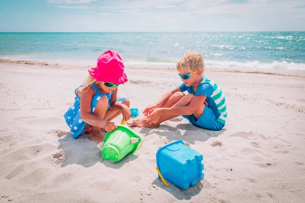 Děti chlapec a dívka hrát s pískem na pláži — Stock fotografie
