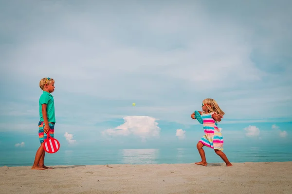 Kinderen-jongen en meisje-play tennis op strand — Stockfoto