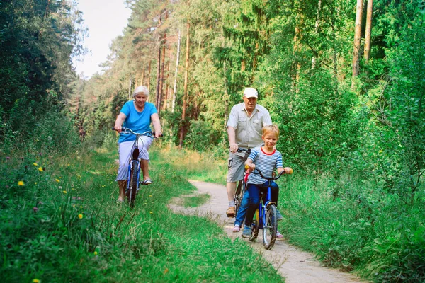 Couple sénior actif avec des enfants à vélo dans la nature — Photo