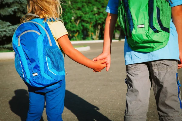 Niño y niña tomados de la mano van a la escuela — Foto de Stock