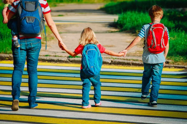 Anne çocukları okula ya da kreşe götürüyor.