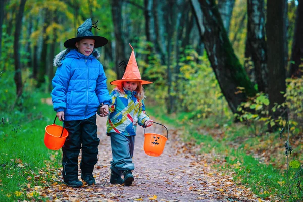 Niños en halloween disfraz truco o tratar en otoño naturaleza —  Fotos de Stock