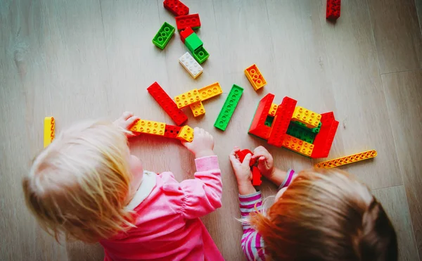 Niños juegan con bloques de plástico de colores, la educación —  Fotos de Stock