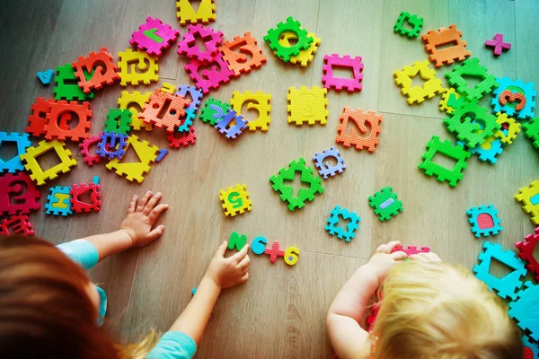 Crianças brincando com quebra-cabeça, aprendendo números e formas — Fotografia de Stock