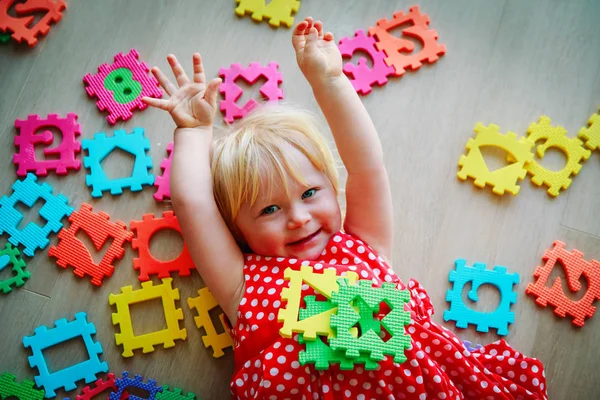 Lycklig liten flicka lära sig siffror och former, leka med pussel — Stockfoto