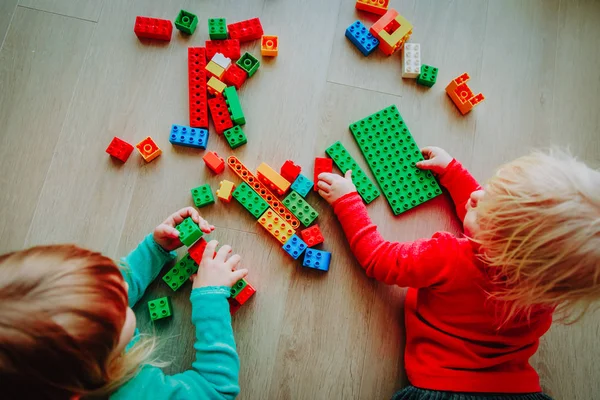 Niños juegan con bloques de plástico de colores, la educación —  Fotos de Stock