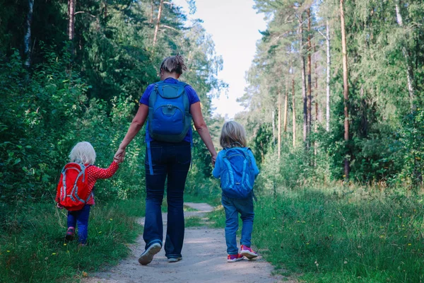 Mãe com dois filhos ir para a escola ou viajar na natureza — Fotografia de Stock