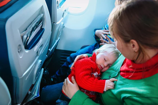 Matka z śpiące dziecko i syn podróży samolotem — Zdjęcie stockowe