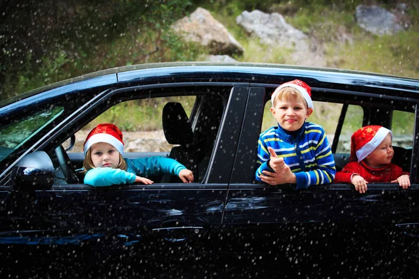 Viaje en coche de navidad- niños felices viajan en invierno —  Fotos de Stock