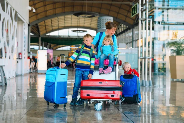 Familj reser - mor med barn och resväskor i flygplats — Stockfoto