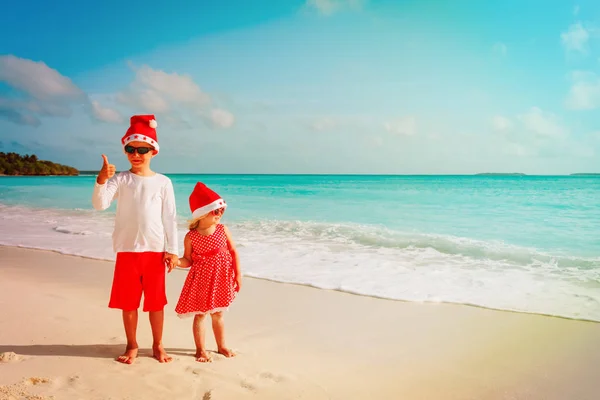 Crianças - menino e menina - celebrando o Natal na praia tropical — Fotografia de Stock