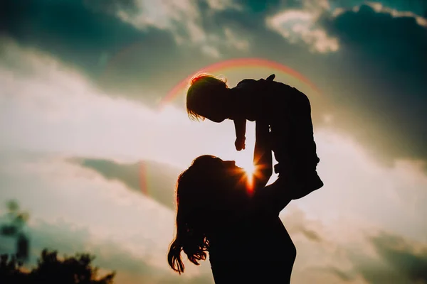 Мати і маленька дитина грають на заході сонця — стокове фото