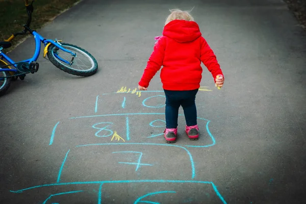 Kleines Mädchen spielt Hopscotch auf Spielplatz im Freien — Stockfoto