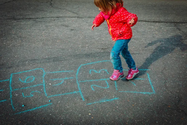 Kleines Mädchen spielt Hopscotch auf Spielplatz im Freien — Stockfoto