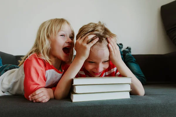 Jongen probeert te boeken lezen, huiswerk terwijl zus schreeuwen — Stockfoto