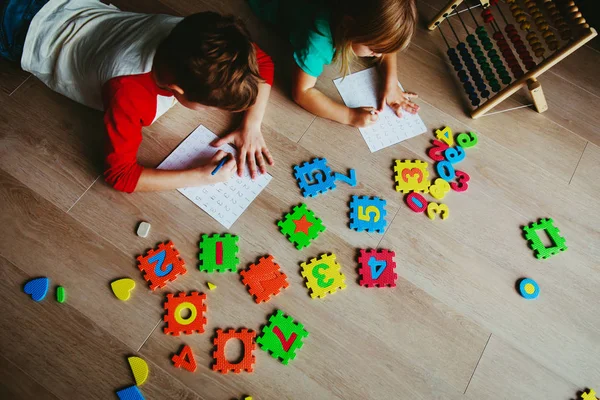Menino e menina aprender a escrever e calcular números — Fotografia de Stock