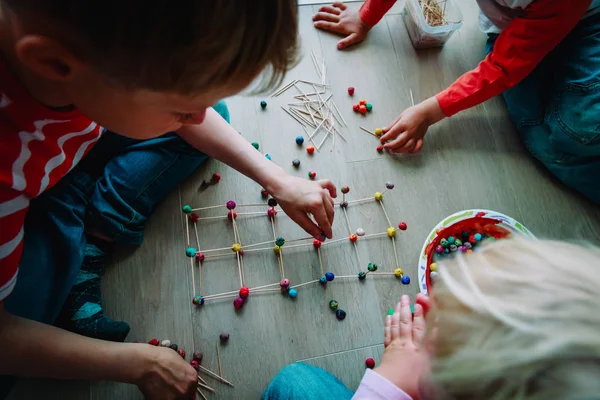Barn att göra geometriska former av pinnar och spela deg — Stockfoto