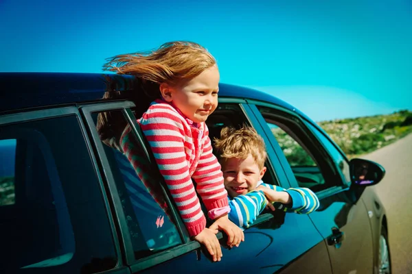 Szczęśliwy małego chłopca i dziewczyny cieszyć podróży samochodem na drodze — Zdjęcie stockowe