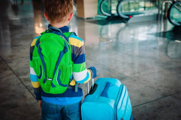 Мальчик с рюкзаком и чемоданом прогулка в аэропорту — стоковое фото