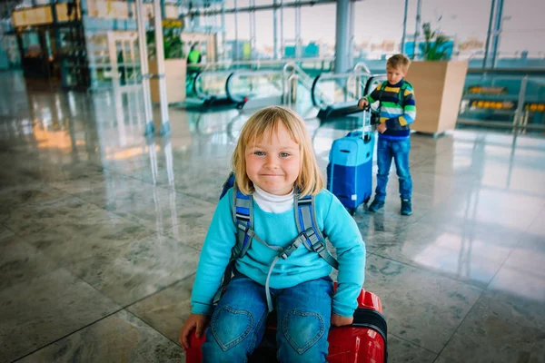Щаслива маленька дівчинка і хлопчик подорожують в аеропорту — стокове фото