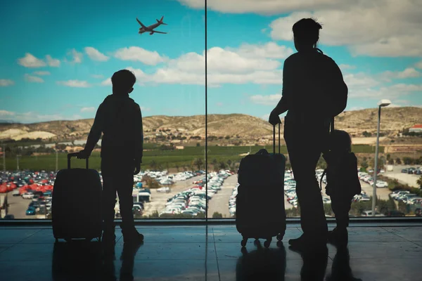 子供と荷物を空港で飛行機を見て母 — ストック写真