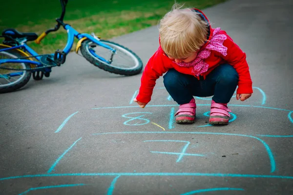 Menina desenhar jogar hopscotch no playground — Fotografia de Stock