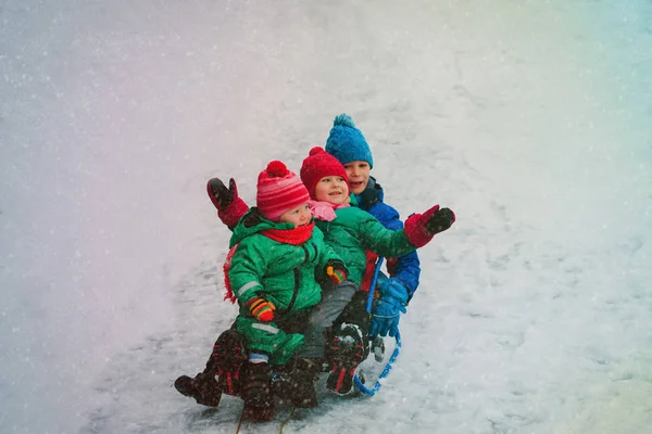 Bambini felici-ragazzo e ragazze-sulla slitta nella neve invernale — Foto Stock