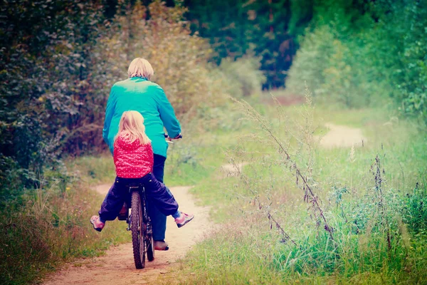 Avó sênior ativa com neta em bicicleta na natureza — Fotografia de Stock