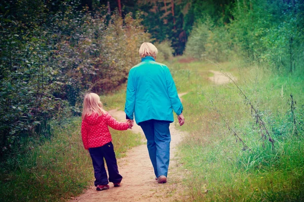 Mormor med barnbarn promenad i naturen — Stockfoto