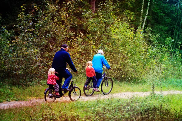 Abuelos mayores activos con niños montando bicicletas en la naturaleza —  Fotos de Stock