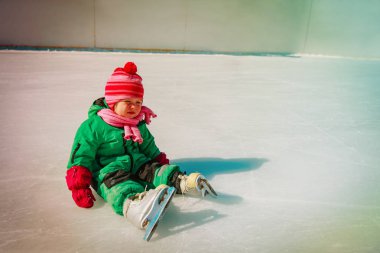 çöküşünden sonra buz paten ile oturan sevimli küçük kız