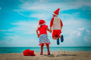 mutlu çocuklar - küçük oğlan ve kız - tropik sahilde Noel kutlamaları