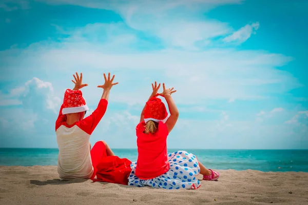 Glückliche Kinder - kleiner Junge und Mädchen - feiern Weihnachten am tropischen Strand — Stockfoto