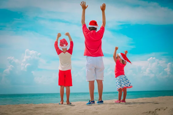 Gelukkig vader met kinderen lopen op tropisch strand met Kerstmis — Stockfoto