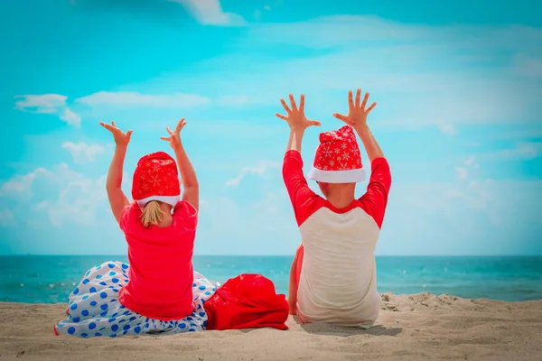 Niños felices, niño y niña, celebrando la Navidad en la playa tropical —  Fotos de Stock
