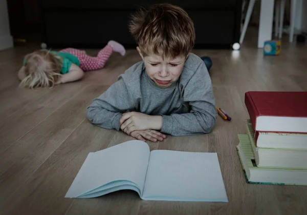 Svårt Hemundervisning-pojken trött på läxor, Syster gråta — Stockfoto