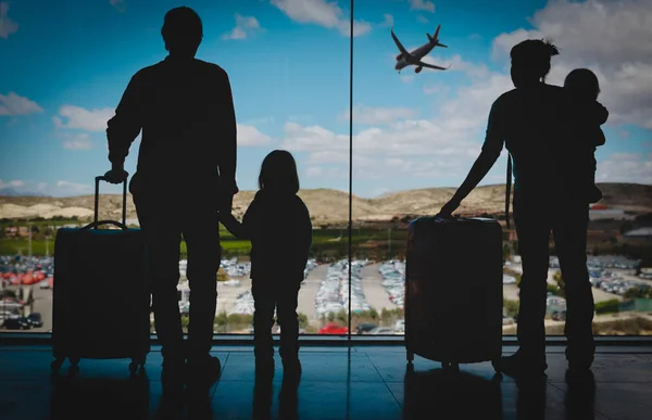Сім'я з дітьми та багаж, що дивиться на літаки в аеропорту — стокове фото