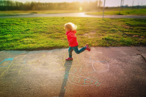 Menina jogar hopscotch no playground no por do sol — Fotografia de Stock