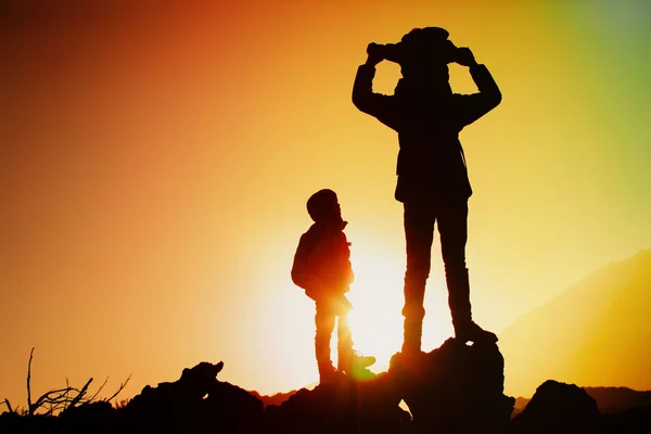 Siluetter av lycklig far med två barn vandring vid solnedgången — Stockfoto