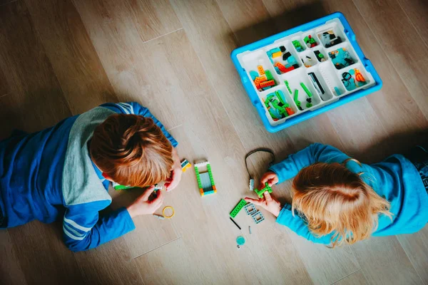 Menina e menino edifício de blocos de plástico coloridos — Fotografia de Stock